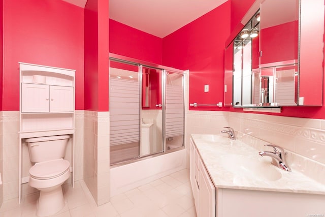 full bathroom featuring tile patterned floors, vanity, tile walls, enclosed tub / shower combo, and toilet