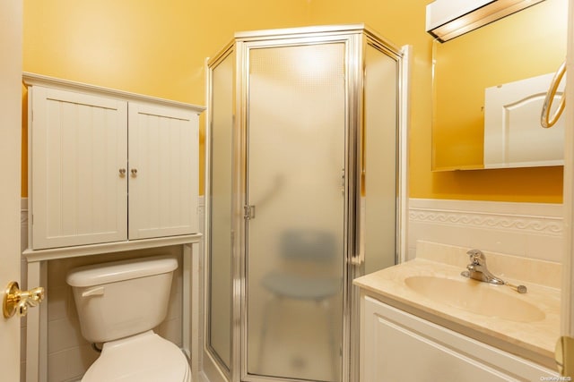 bathroom featuring vanity, toilet, and a shower with shower door