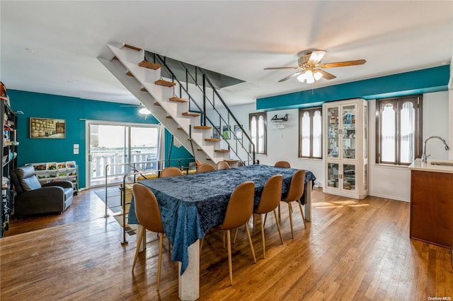 dining space with ceiling fan, sink, and hardwood / wood-style flooring