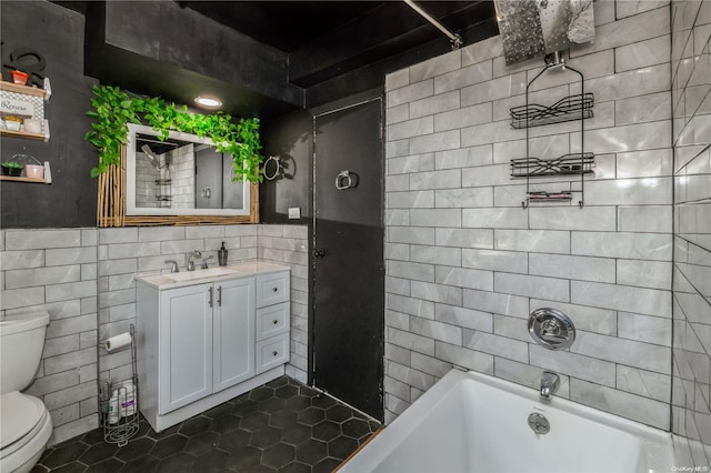 full bathroom featuring tile patterned floors, vanity,  shower combination, tile walls, and toilet