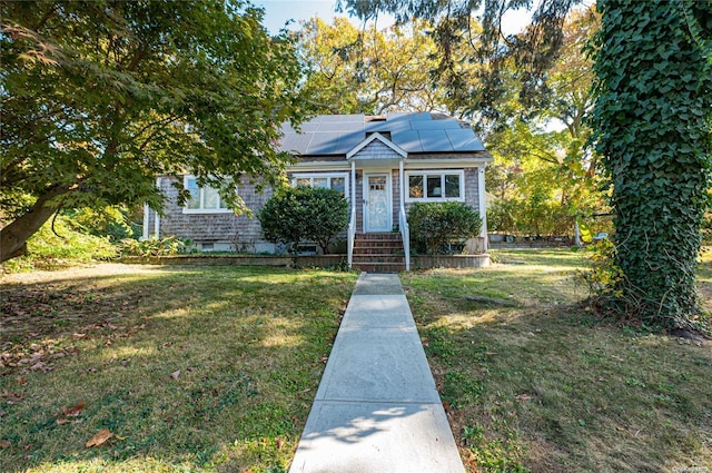 bungalow-style home with solar panels and a front lawn