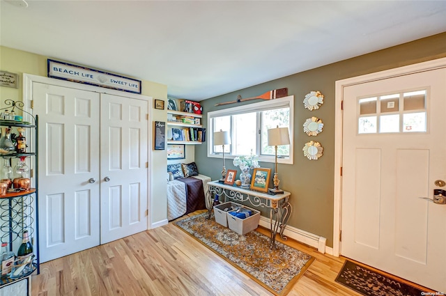 foyer with light hardwood / wood-style flooring and a baseboard heating unit