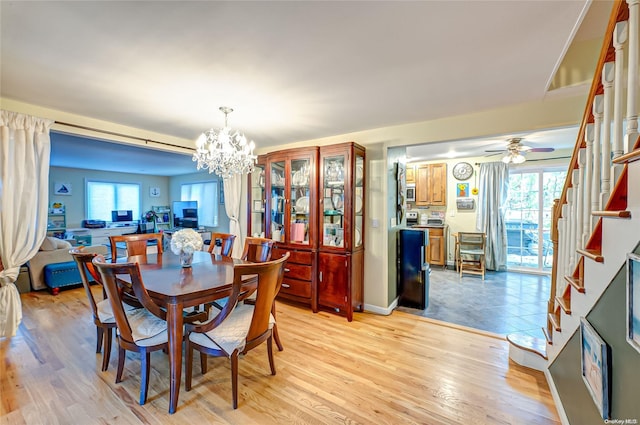 dining space with ceiling fan with notable chandelier, light hardwood / wood-style floors, and a healthy amount of sunlight