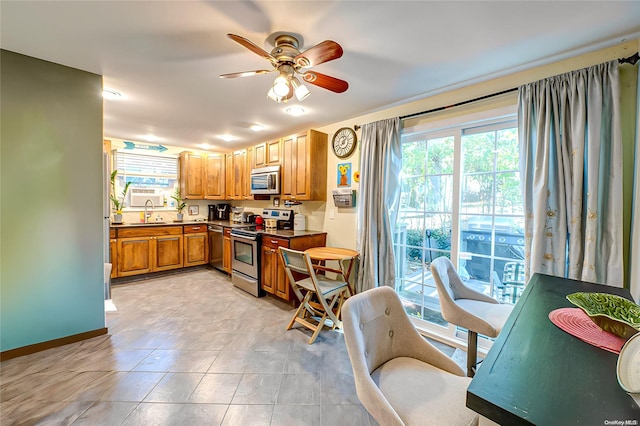 kitchen featuring light tile patterned flooring, stainless steel appliances, ceiling fan, and sink