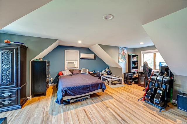 bedroom featuring a wall mounted air conditioner, light hardwood / wood-style floors, vaulted ceiling, and cooling unit