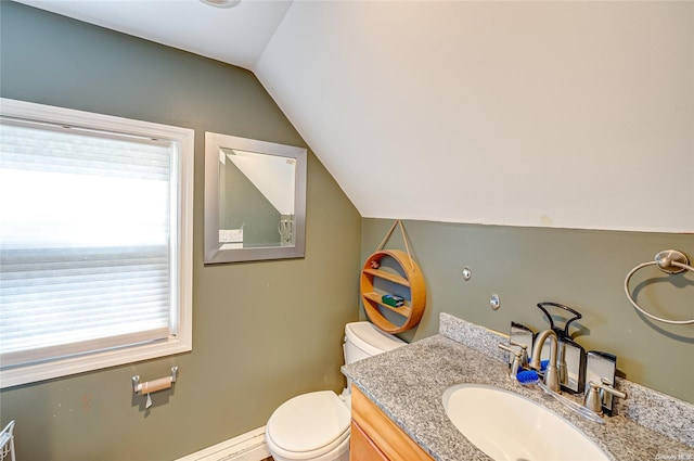 bathroom with toilet, vanity, and vaulted ceiling