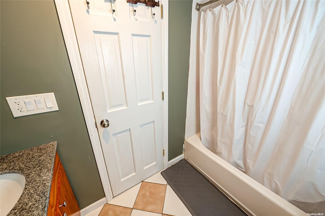 bathroom featuring tile patterned floors, shower / bath combo with shower curtain, and vanity