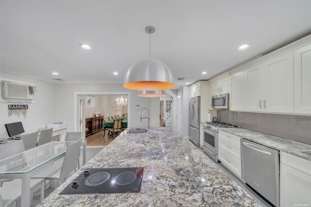 kitchen with sink, stainless steel appliances, light stone counters, pendant lighting, and white cabinets