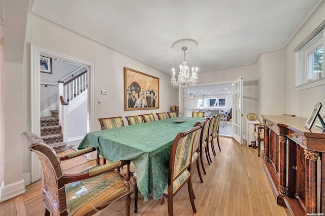 dining area featuring light hardwood / wood-style floors and an inviting chandelier