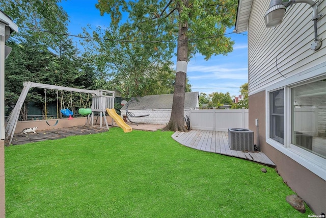 view of yard with a playground, a wooden deck, and cooling unit