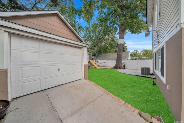 garage featuring central AC unit and a lawn