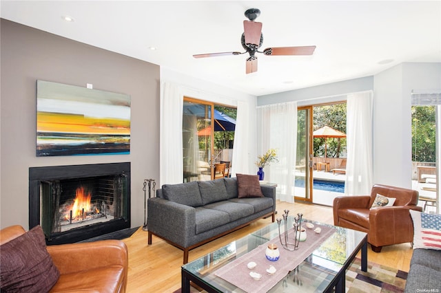 living room featuring light hardwood / wood-style flooring and ceiling fan