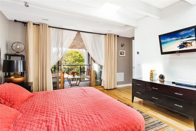 bedroom with beamed ceiling, access to outside, and light hardwood / wood-style flooring