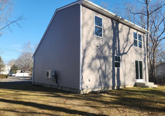 view of side of property featuring ac unit and a yard