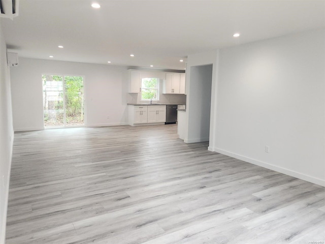 unfurnished living room with sink and light hardwood / wood-style floors