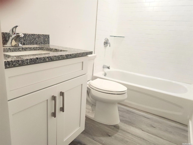 full bathroom with wood-type flooring, bathing tub / shower combination, vanity, and toilet