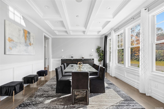 dining area featuring wood-type flooring, coffered ceiling, a healthy amount of sunlight, and beamed ceiling