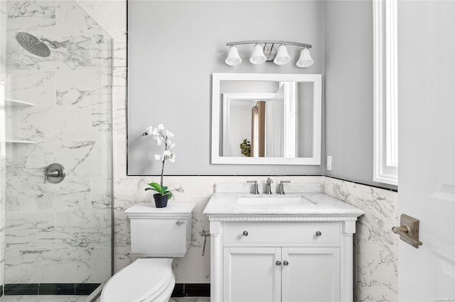 bathroom with tiled shower, toilet, tile walls, and vanity