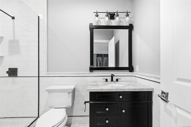 bathroom with vanity, toilet, tile walls, and a tile shower