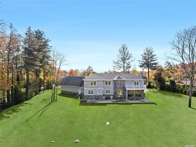 rear view of house with a patio and a yard