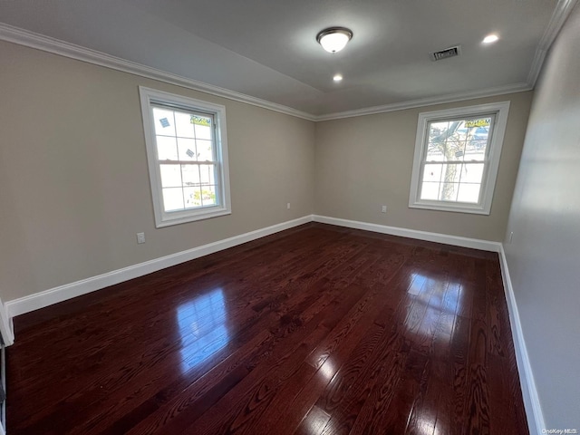 empty room featuring dark hardwood / wood-style flooring and crown molding