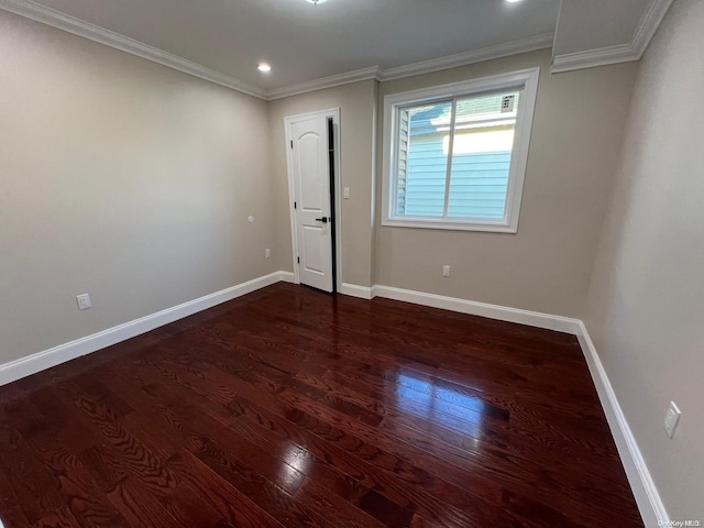 empty room with dark hardwood / wood-style floors and ornamental molding