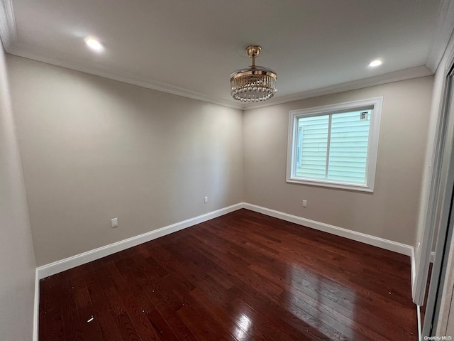 unfurnished room with dark hardwood / wood-style floors, ornamental molding, and a notable chandelier