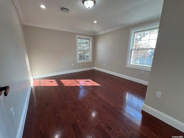 empty room featuring ornamental molding and dark wood-type flooring