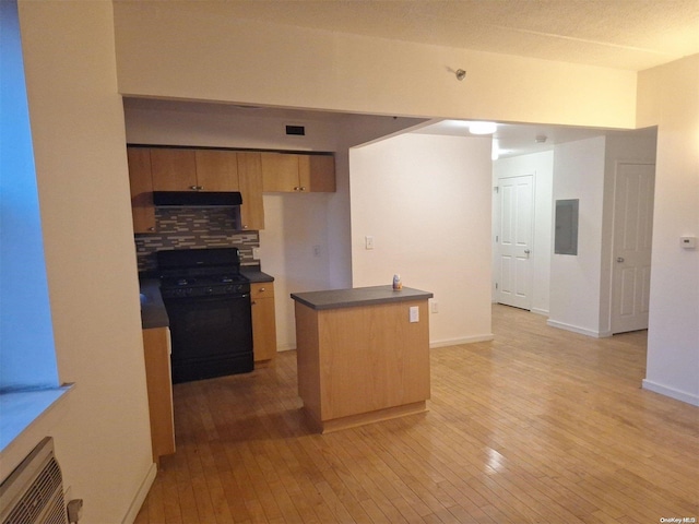 kitchen with an AC wall unit, electric panel, black stove, and light hardwood / wood-style floors