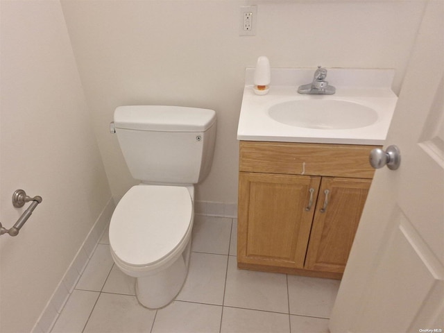 bathroom with toilet, vanity, and tile patterned floors