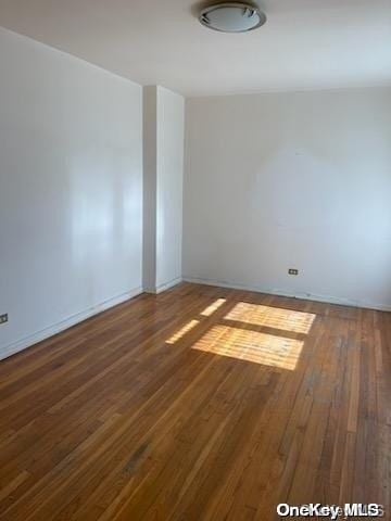 unfurnished room with dark hardwood / wood-style flooring