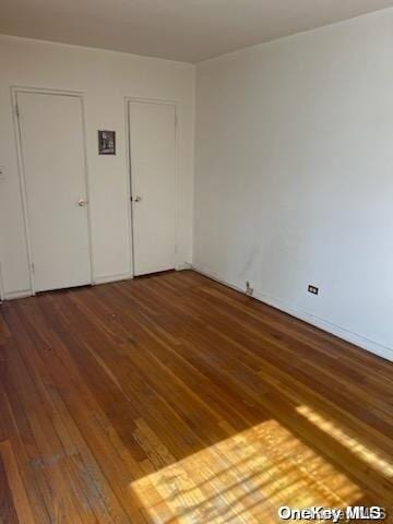 unfurnished bedroom with dark hardwood / wood-style flooring