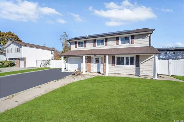 view of front of house featuring solar panels, a garage, and a front lawn