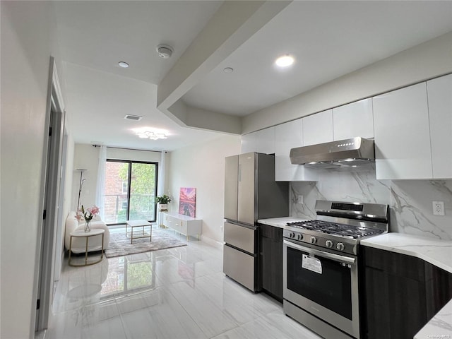 kitchen featuring decorative backsplash, white cabinetry, light stone counters, and appliances with stainless steel finishes