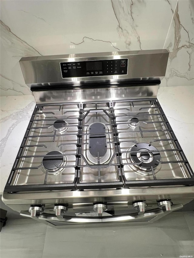 interior details featuring stainless steel stove and light stone counters