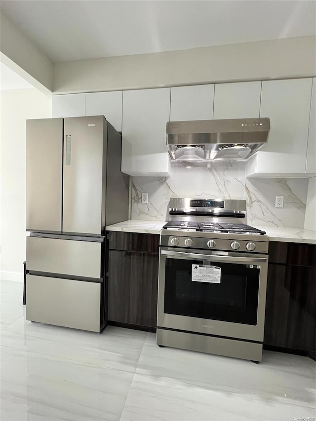 kitchen featuring exhaust hood, white cabinets, decorative backsplash, dark brown cabinets, and stainless steel appliances