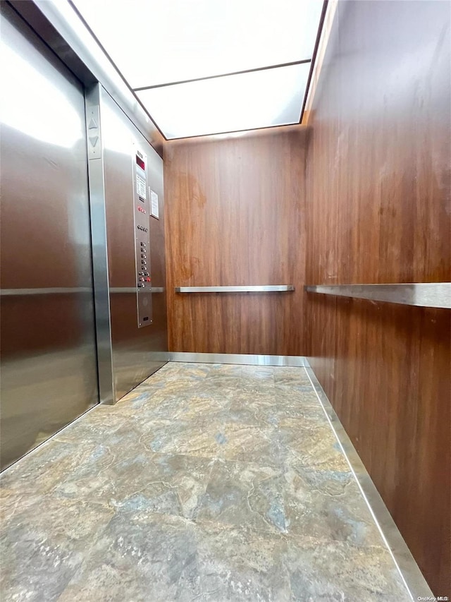 interior space with elevator and wooden walls