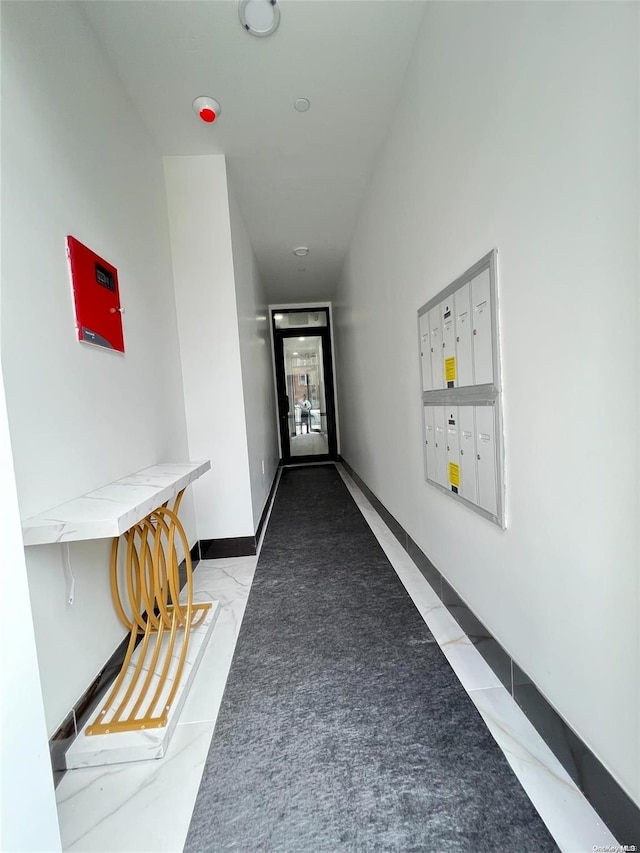 hallway featuring light tile patterned floors and a mail area