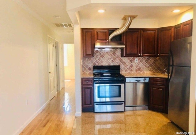 kitchen featuring light wood-type flooring, stainless steel appliances, and tasteful backsplash