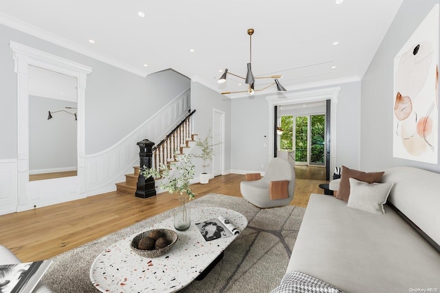 living room with light hardwood / wood-style flooring, a notable chandelier, and crown molding