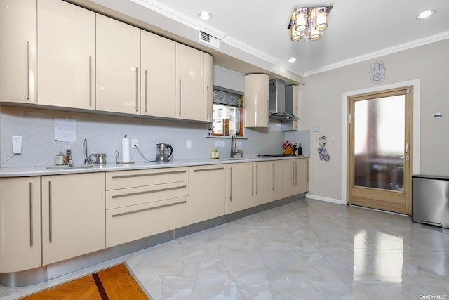 kitchen with sink, wall chimney exhaust hood, ornamental molding, tasteful backsplash, and stainless steel gas cooktop