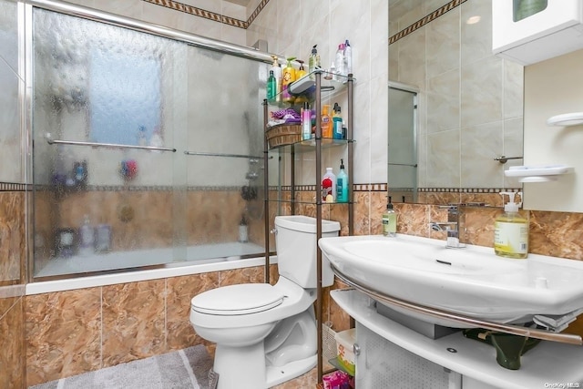 full bathroom with shower / bath combination with glass door, vanity, toilet, and tile walls