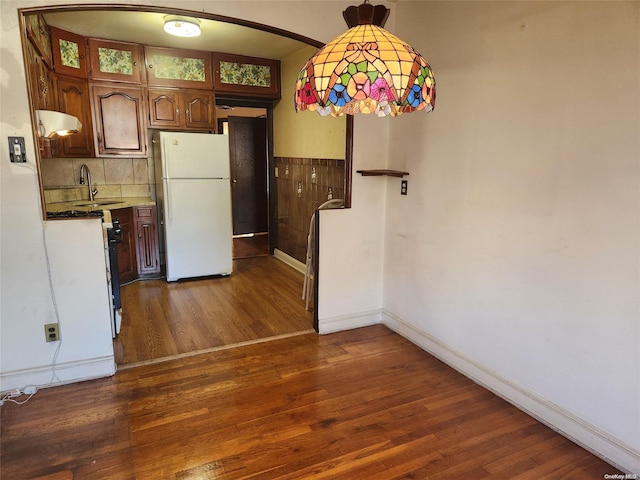 kitchen featuring backsplash, white appliances, sink, pendant lighting, and dark hardwood / wood-style floors