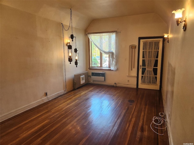 spare room with lofted ceiling, heating unit, and dark wood-type flooring