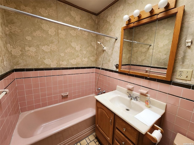 full bathroom featuring vanity, tile patterned floors, tiled shower / bath, toilet, and tile walls