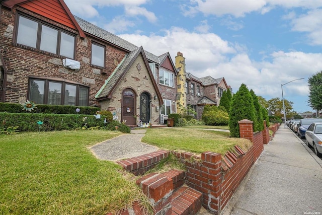 english style home with a front lawn