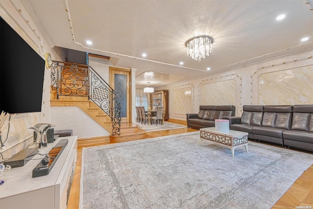 living room with an inviting chandelier, crown molding, and light parquet flooring