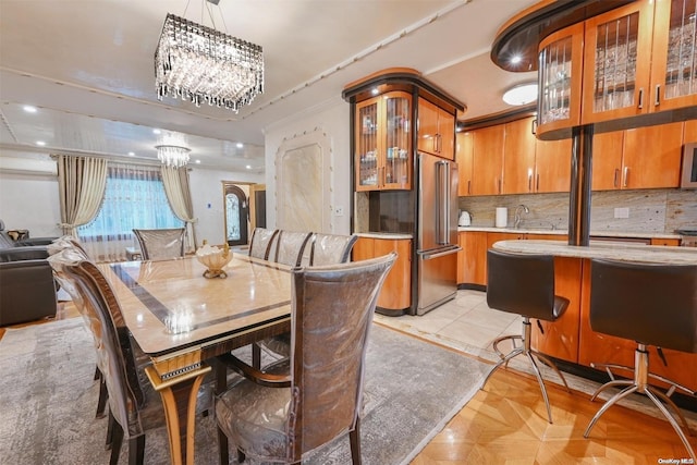 dining space with a chandelier, light parquet flooring, and sink