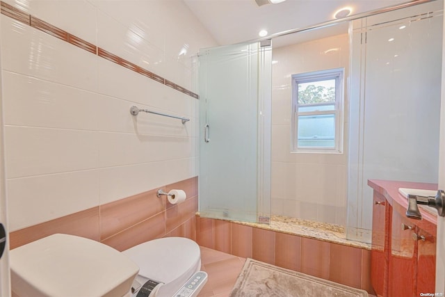 bathroom with tile walls, toilet, and combined bath / shower with glass door