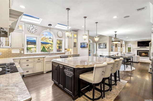 kitchen featuring a center island, light stone counters, and a healthy amount of sunlight